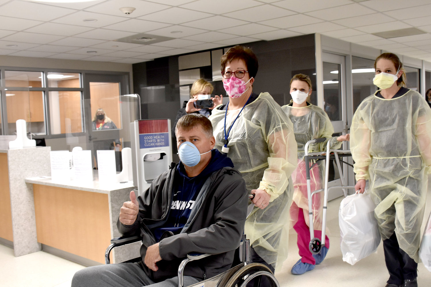 Christopher Blynn, pushed in a wheelchair by Linda Cherico, RN, gives a thumbs up to health care workers and visitors as he was discharged from Wayne Memorial Hospital...